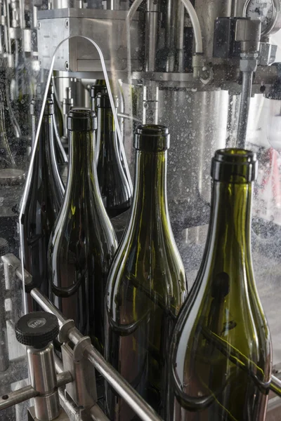 Italy, Sicily, wine bottles being washed and filled with wine by an industrial machine in a wine factory — Stock Photo, Image