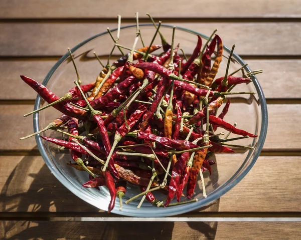 シチリアの赤い木製のテーブルの上にボウルに唐辛子を乾燥します。 — ストック写真
