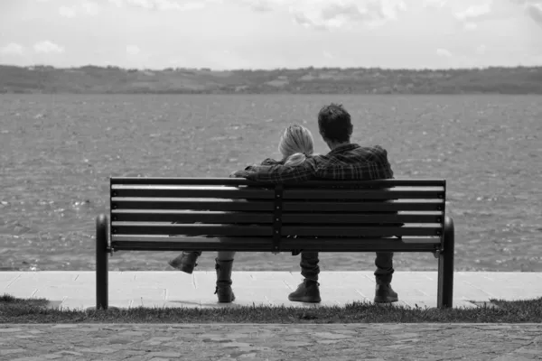 Itália, Lago Bracciano - Roma, jovem casal relaxante em um banco — Fotografia de Stock