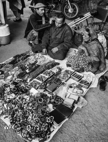 Um vendedor de rua está a limpar os ouvidos. — Fotografia de Stock