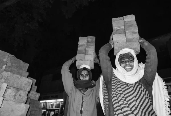 Femmes indiennes portant des briques sur la tête — Photo