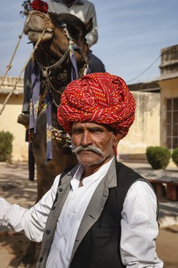 Hindistan, rajasthan, jaipur, geleneksel giysiler tutan Hintli adam deve olduğunu