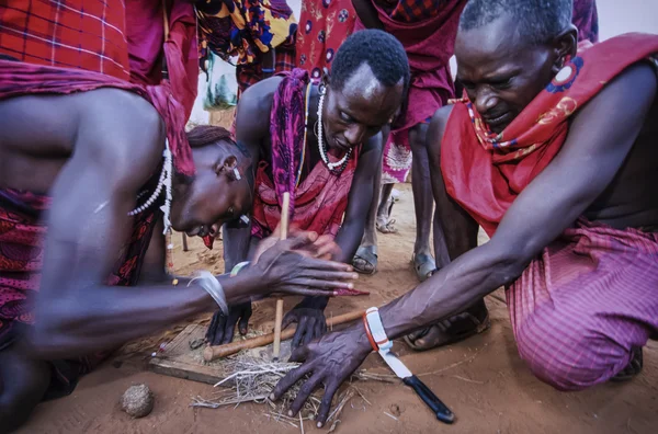 Кения, Восточный национальный парк Цаво, деревня Масаи, мужчины масаи разводят огонь — стоковое фото