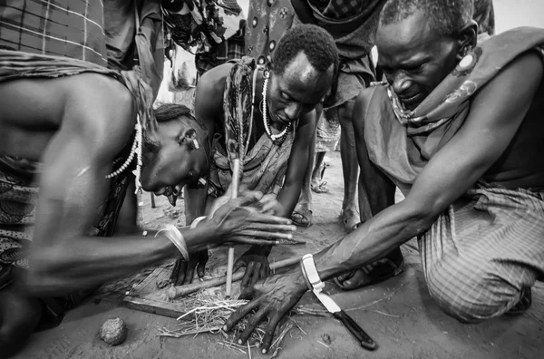 Kenia, Tsavo East National Park, Masai village, Masai men making fire — Foto de Stock