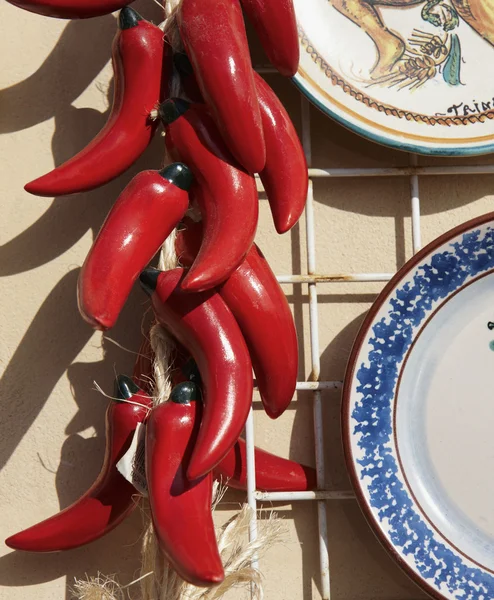 Italy, Sicily, Siracusa, ceramic red hot chili peppers and hand painted decorative plates for sale in a local store — Stock Photo, Image