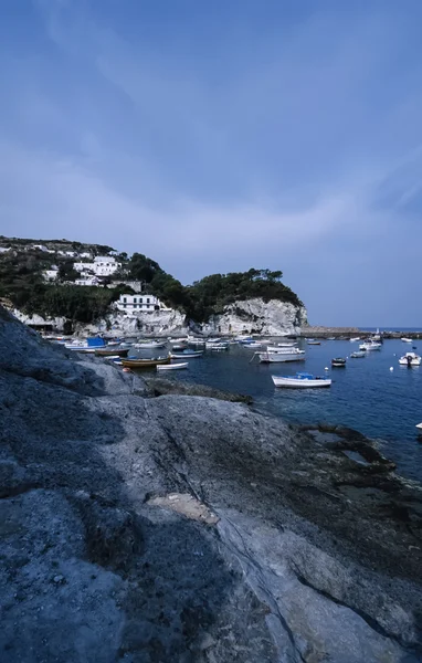 Yerel balıkçı tekneleri ve adanın kayalık sahil görünümü — Stok fotoğraf