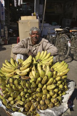 Yerel bir pazarda muz satan Hintli adam