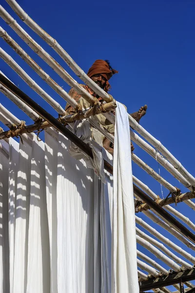 Homem indiano pendurado roupas de algodão para secar sob o sol — Fotografia de Stock