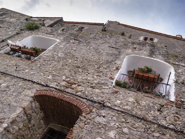 Itália, Toscana, Capalbio, pequenas janelas nas paredes externas da cidade velha — Fotografia de Stock