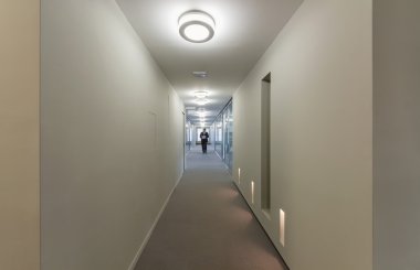 bir ofis koridorunda yürürken iş adamı