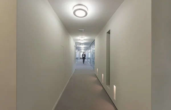 Homem de negócios caminhando em um corredor de escritório — Fotografia de Stock