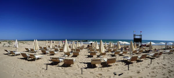 Палубные стулья и пляжные зонтики — стоковое фото