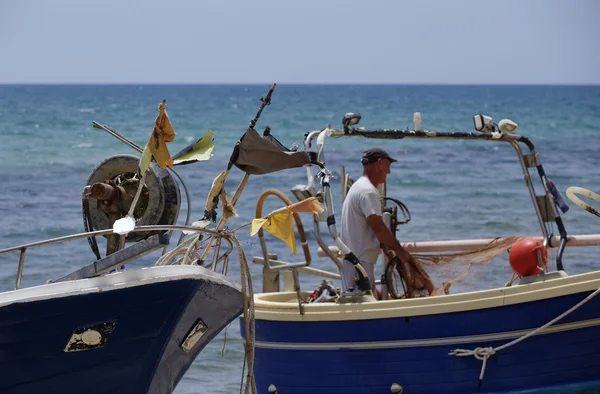 Pescador trabalhando em terra em seu barco de pesca — Fotografia de Stock