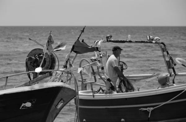 Pescador trabajando en tierra en su barco de pesca — Foto de Stock