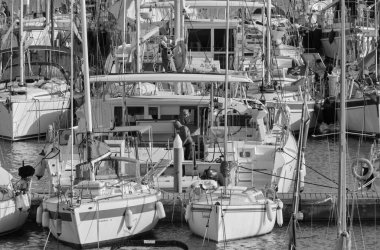 İtalya, Sicilya, Akdeniz, Marina di Ragusa (Ragusa Eyaleti); 30 Eylül 2021, limandaki bir yelkenli ve lüks yatlarda bir adam - EDITORIAL