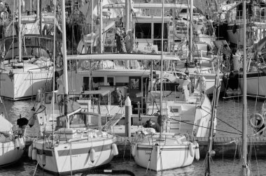 İtalya, Sicilya, Akdeniz, Marina di Ragusa (Ragusa Eyaleti); 30 Eylül 2021, limandaki bir yelkenli ve lüks yatlarda bir adam - EDITORIAL