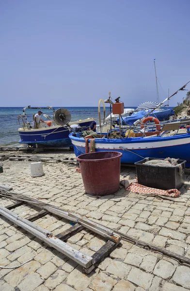 Pescador trabajando en tierra en su barco de pesca — Foto de Stock