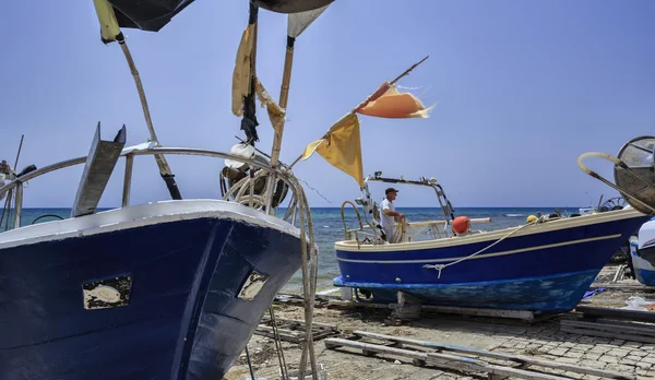 Pescador trabajando en tierra en su barco de pesca — Foto de Stock