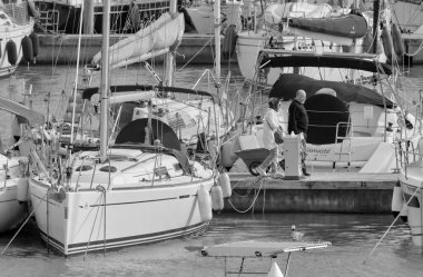 İtalya, Sicilya, Akdeniz, Marina di Ragusa (Ragusa ili); 24 Ekim 2021, limandaki insanlar ve yelkenliler - EDITORIAL