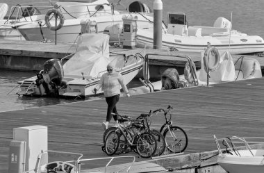 İtalya, Sicilya, Akdeniz, Marina di Ragusa (Ragusa ili); 27 Ekim 2021, limandaki insanlar, motorlu tekneler ve lüks yatlar - EDITORIAL