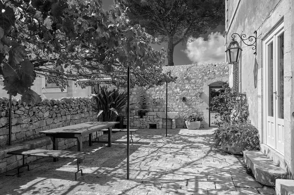 意大利 西西里 莫迪卡 拉古萨省 有一张桌子和一个旧石屋的座位的侧花园 — 图库照片