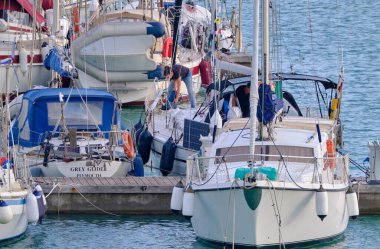 İtalya, Sicilya, Akdeniz, Marina di Ragusa (Ragusa Eyaleti); 1 Kasım 2021, limandaki bir yelkenli teknesinde kadın - EDITORIAL