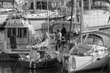 İtalya, Sicilya, Akdeniz, Marina di Ragusa (Ragusa Eyaleti); 13 Kasım 2021, limanda bisiklet ve lüks yatları olan adam - EDITORIAL