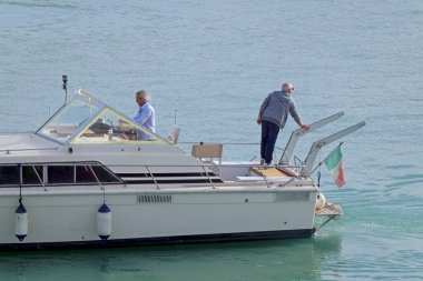 İtalya, Sicilya, Akdeniz, Marina di Ragusa (Ragusa Eyaleti); 13 Kasım 2021, limanda lüks bir yatta erkekler - EDITORIAL