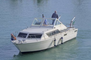 İtalya, Sicilya, Akdeniz, Marina di Ragusa (Ragusa Eyaleti), limanda lüks bir yatta bulunan erkekler 