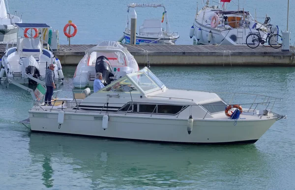 İtalya, Sicilya, Akdeniz, Marina di Ragusa (Ragusa Eyaleti); 13 Kasım 2021, limanda lüks bir yatta erkekler - EDITORIAL