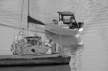 İtalya, Sicilya, Akdeniz, Marina di Ragusa (Ragusa Eyaleti); 20 Kasım 2021, bir motorlu tekne ve limanda bir yelkenli balıkçısı - EDITORIAL