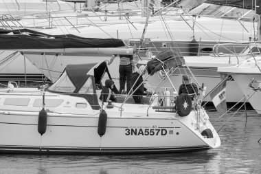 İtalya, Sicilya, Akdeniz, Marina di Ragusa (Ragusa Eyaleti); 21 Kasım 2021, limandaki bir yelkenli ve lüks yatlarda yaşayan insanlar - EDITORIAL