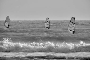 İtalya, Sicilya, Akdeniz, Marina di Ragusa (Ragusa ili); 7 Aralık 2021, denizde rüzgar sörfçüleri - EDITORIAL