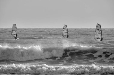 İtalya, Sicilya, Akdeniz, Marina di Ragusa (Ragusa ili); 7 Aralık 2021, denizde rüzgar sörfçüleri - EDITORIAL