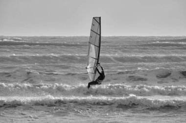 İtalya, Sicilya, Akdeniz, Marina di Ragusa (Ragusa ili); 7 Aralık 2021, denizde rüzgar sörfçüsü - EDITORIAL