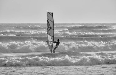 İtalya, Sicilya, Akdeniz, Marina di Ragusa (Ragusa ili); 7 Aralık 2021, denizde rüzgar sörfçüsü - EDITORIAL