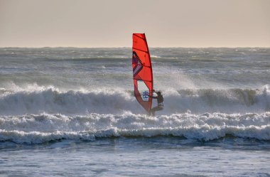 İtalya, Sicilya, Akdeniz, Marina di Ragusa (Ragusa ili); 7 Aralık 2021, denizde rüzgar sörfçüsü - EDITORIAL