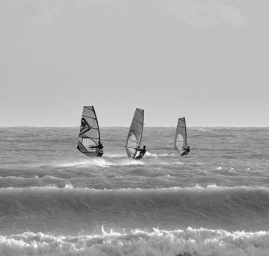 İtalya, Sicilya, Akdeniz, Marina di Ragusa (Ragusa ili); 7 Aralık 2021, denizde rüzgar sörfçüleri - EDITORIAL