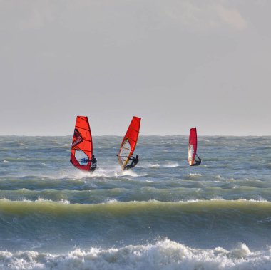 İtalya, Sicilya, Akdeniz, Marina di Ragusa (Ragusa ili); 7 Aralık 2021, denizde rüzgar sörfçüleri - EDITORIAL