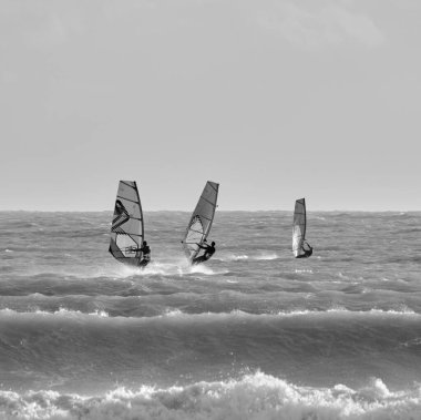 İtalya, Sicilya, Akdeniz, Marina di Ragusa (Ragusa ili); 7 Aralık 2021, denizde rüzgar sörfçüleri - EDITORIAL