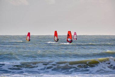 İtalya, Sicilya, Akdeniz, Marina di Ragusa (Ragusa ili); 7 Aralık 2021, denizde rüzgar sörfçüleri - EDITORIAL