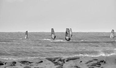 İtalya, Sicilya, Akdeniz, Marina di Ragusa (Ragusa ili); 7 Aralık 2021, denizde rüzgar sörfçüleri - EDITORIAL