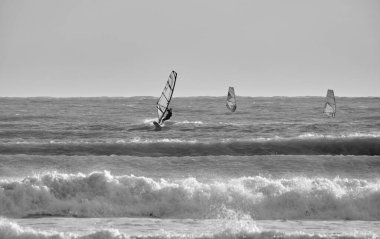 İtalya, Sicilya, Akdeniz, Marina di Ragusa (Ragusa ili); 7 Aralık 2021, denizde rüzgar sörfçüleri - EDITORIAL