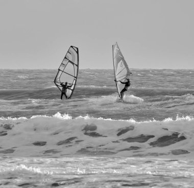 İtalya, Sicilya, Akdeniz, Marina di Ragusa (Ragusa ili); 7 Aralık 2021, denizde rüzgar sörfçüleri - EDITORIAL