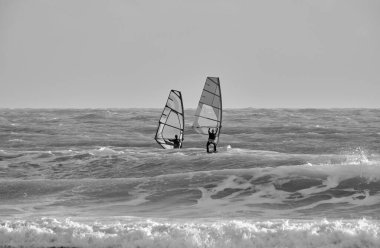 İtalya, Sicilya, Akdeniz, Marina di Ragusa (Ragusa ili); 7 Aralık 2021, denizde rüzgar sörfçüleri - EDITORIAL