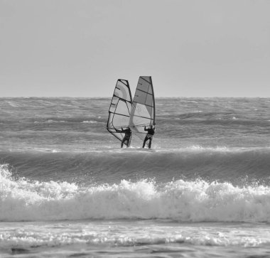 İtalya, Sicilya, Akdeniz, Marina di Ragusa (Ragusa ili); 7 Aralık 2021, denizde rüzgar sörfçüleri - EDITORIAL