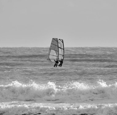 İtalya, Sicilya, Akdeniz, Marina di Ragusa (Ragusa ili); 7 Aralık 2021, denizde rüzgar sörfçüleri - EDITORIAL