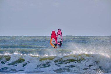 İtalya, Sicilya, Akdeniz, Marina di Ragusa (Ragusa ili); 7 Aralık 2021, denizde rüzgar sörfçüleri - EDITORIAL