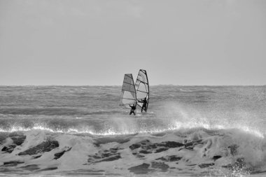 İtalya, Sicilya, Akdeniz, Marina di Ragusa (Ragusa ili); 7 Aralık 2021, denizde rüzgar sörfçüleri - EDITORIAL