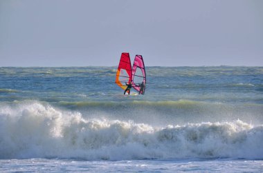 İtalya, Sicilya, Akdeniz, Marina di Ragusa (Ragusa ili); 7 Aralık 2021, denizde rüzgar sörfçüleri - EDITORIAL